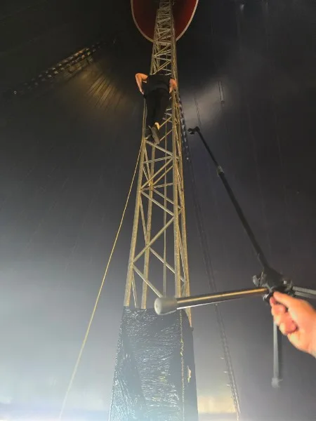 A member of Heck scaling a tent support