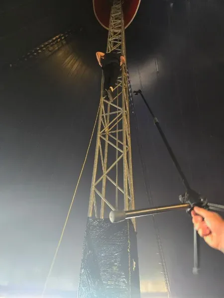 A member of Heck scaling a tent support